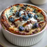 Warm, fluffy Baked Protein Pancake Bowl with fresh berries and a drizzle of honey.