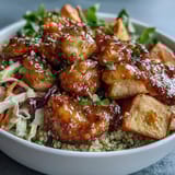 Plated Hot Honey Chicken Bowl with golden roasted sweet potatoes and fluffy quinoa. The vibrant red cabbage slaw and tangy dressing add a crunchy, spicy finish.