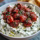 Creamy whipped feta topped with sweet, caramelized cherry tomatoes and fresh basil, perfect for a Mediterranean appetizer.  