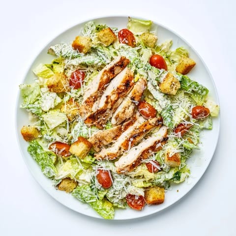 Yogurt Caesar Grilled Chicken Salad is served with cherry tomatoes and croutons, ready for a light lunch.  