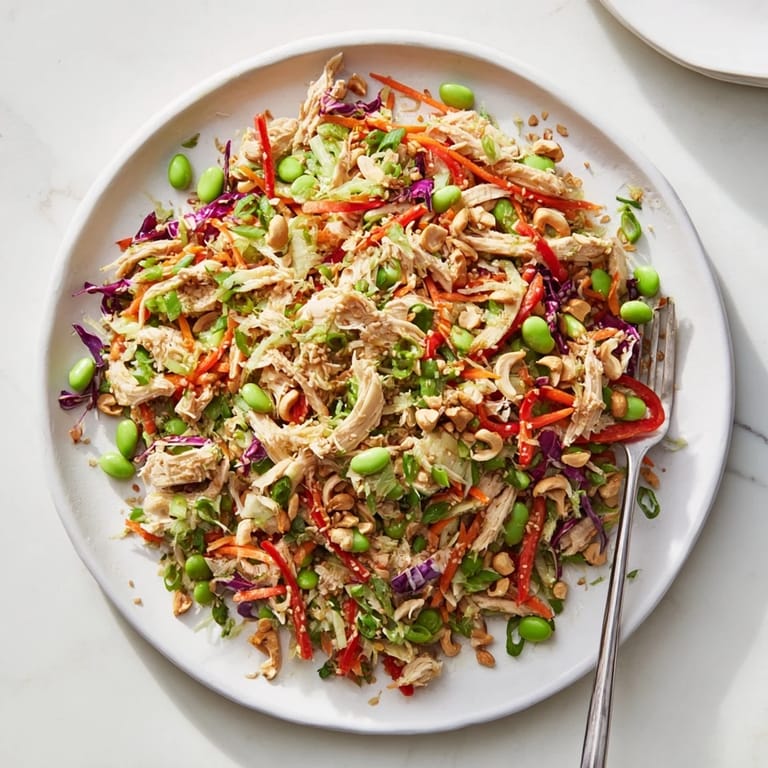 Edamame Crunch Chicken Salad with tender shredded chicken, crunchy veggies, and toasted sesame seeds on a serving platter.