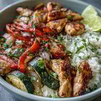 Sizzling chicken and peppers for Sheet Pan Fajita Bowls, roasted with smoky spices.