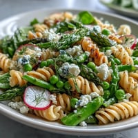 Spring Pasta Salad with Lemon Vinaigrette and Radishes—a colorful mix of crisp snap peas, asparagus, and radishes tossed in a bright lemon dressing.