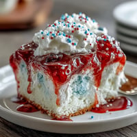 Festive Memorial Day Red White Blue Poke Cake, swirled with vibrant colors and creamy topping.